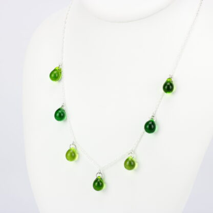 Collier chaine corde en argent 925 avec sept perles de verre aux tons camaïeu de vert. Collier mi-long avec les gouttes de verre disposées tout autour de la chaîne au niveau du buste. Perles lumineuses et transparentes. -Atelier horizon verre