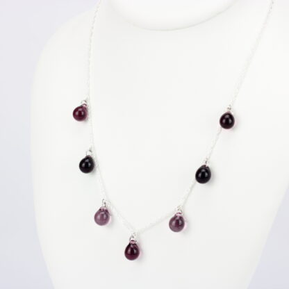 Collier chaine corde en argent 925 avec sept perles de verre aux tons camaïeu de violet. Collier mi-long avec les gouttes de verre disposées tout autour de la chaîne au niveau du buste. Perles lumineuses et transparentes. -Atelier horizon verre