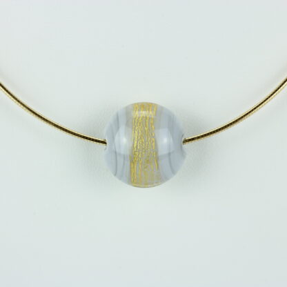 Bijoux . Collier une perle de verre forme lentille de couleur gris avec incrustation d'une bande de feuille d'or. Monture en argent 925, finition dorée. Travail au chalumeau. Fait main. -Atelier horizon verre