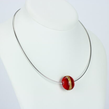 Bijoux . Collier une perle de verre forme lentille de couleur rouge avec incrustation d'une bande de feuille d'or. Monture en argent 925. Travail au chalumeau. Fait main. -Atelier horizon verre