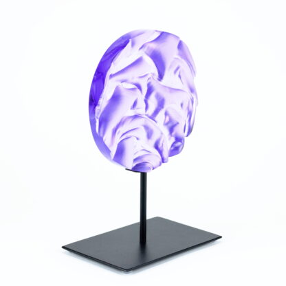 Pièce d'art décoratif de forme circulaire en cristal nommé "Magma" de taille moyenne (18 cm de diamètre). Objet avec du relief, texturés, avec des effets de drapé. Pièce en cristal de couleur violet sur support en métal thermolaqué noir. Pâte de verre. -Atelier horizon verre