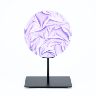 Pièce d'art décoratif de forme circulaire en cristal nommé "Magma" de taille moyenne (18 cm de diamètre). Objet avec du relief, texturés, avec des effets de drapé. Pièce en cristal de couleur violet sur support en métal thermolaqué noir. Pâte de verre. -Atelier horizon verre