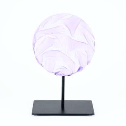 Pièce d'art décoratif de forme circulaire en cristal nommé "Magma" de taille moyenne (18 cm de diamètre). Objet avec du relief, texturés, avec des effets de drapé. Pièce en cristal de couleur violet sur support en métal thermolaqué noir. Pâte de verre. -Atelier horizon verre