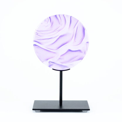 Pièce d'art décoratif de forme circulaire en cristal nommé "Magma" de taille petite (12 cm de diamètre). Objet avec du relief, texturés, avec des effets de drapé. Pièce en cristal de couleur violet sur support en métal thermolaqué noir. Pâte de verre. -Atelier horizon verre