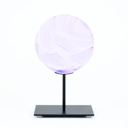 Pièce d'art décoratif de forme circulaire en cristal nommé "Magma" de taille petite (12 cm de diamètre). Objet avec du relief, texturés, avec des effets de drapé. Pièce en cristal de couleur violet sur support en métal thermolaqué noir. Pâte de verre -Atelier horizon verre